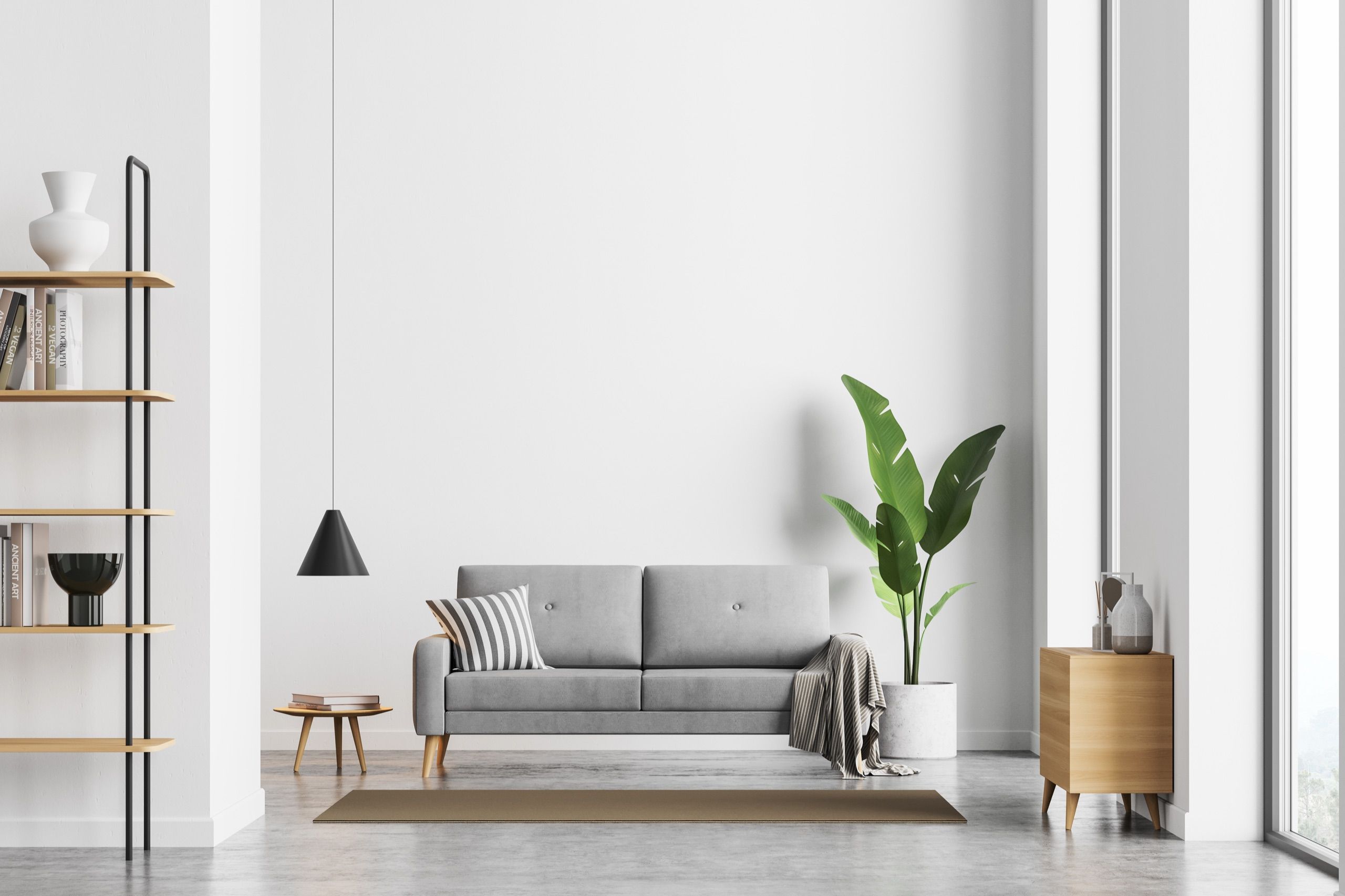 Hell renoviertes Wohnzimmer mit grauem Sofa und frisch gestrichenen weißen Wänden